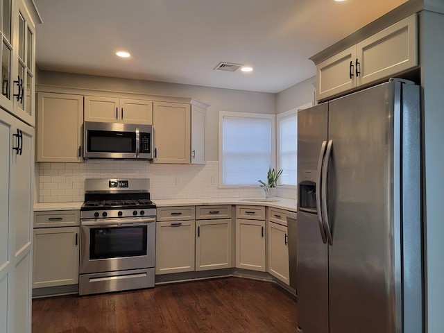 kitchen featuring dark wood-style flooring, a sink, visible vents, light countertops, and appliances with stainless steel finishes