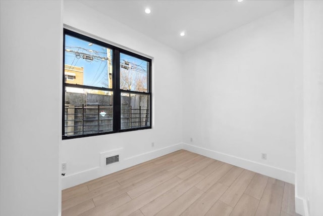 unfurnished room with light wood-style floors, visible vents, baseboards, and recessed lighting