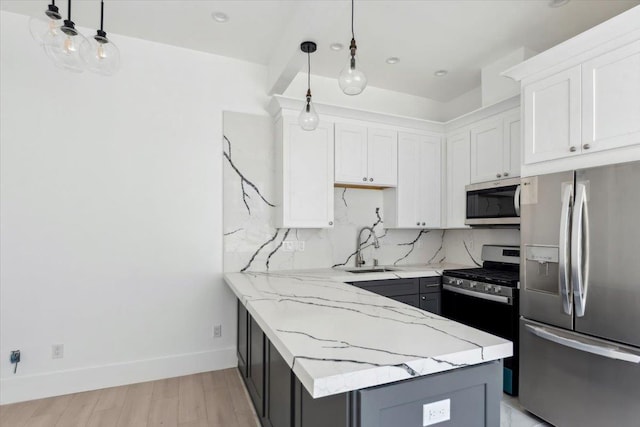 kitchen with stainless steel appliances, pendant lighting, white cabinets, and light stone counters