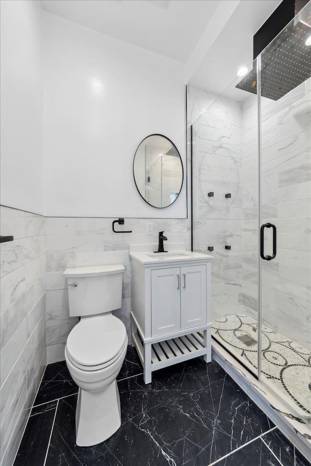 full bathroom with marble finish floor, toilet, wainscoting, a shower stall, and vanity