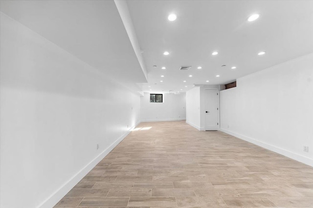 finished basement with light wood-style floors, baseboards, visible vents, and recessed lighting