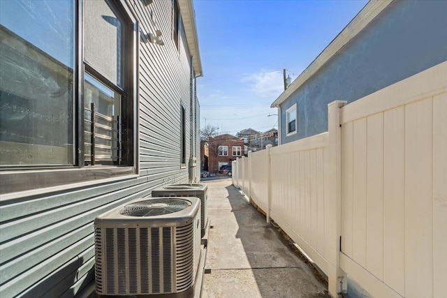 view of side of home featuring cooling unit and fence