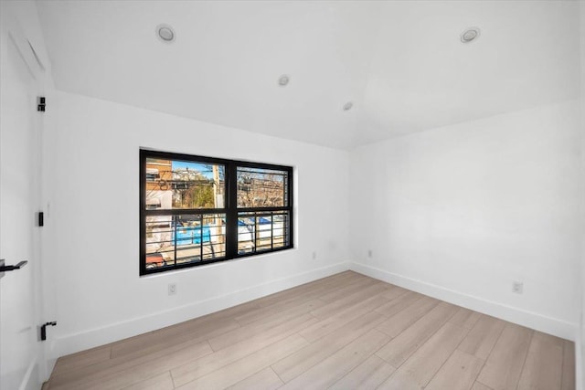 empty room featuring light wood finished floors and baseboards