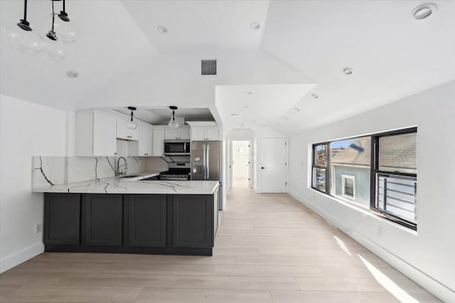 kitchen featuring visible vents, appliances with stainless steel finishes, white cabinetry, a sink, and a peninsula