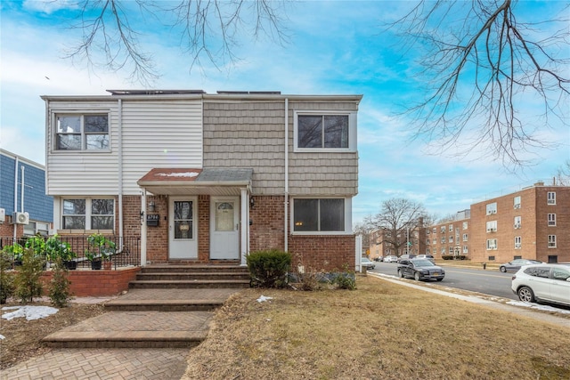 view of front of house featuring entry steps, brick siding, and a front yard