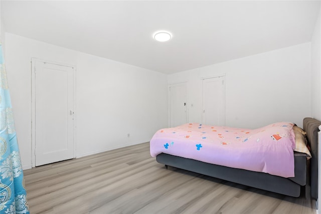 bedroom featuring light wood-style floors and baseboards