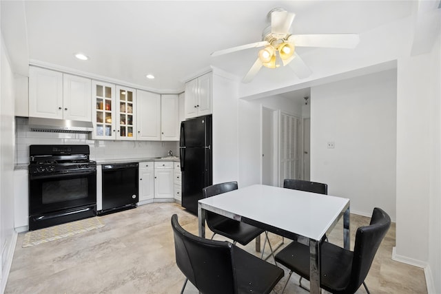 kitchen with white cabinets, glass insert cabinets, under cabinet range hood, light countertops, and black appliances