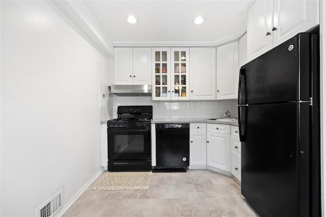 kitchen featuring glass insert cabinets, light countertops, black appliances, white cabinetry, and exhaust hood