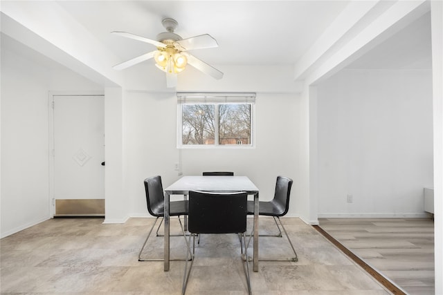 dining room featuring a ceiling fan, light wood-style flooring, and baseboards