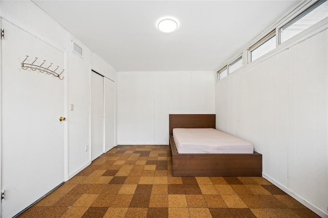 unfurnished bedroom featuring dark floors and visible vents