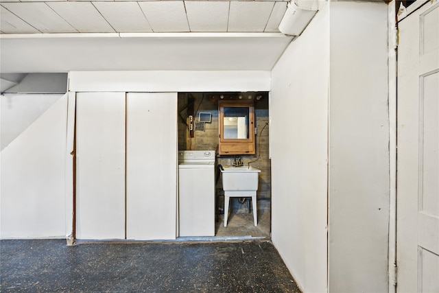 below grade area featuring washer / clothes dryer and a sink