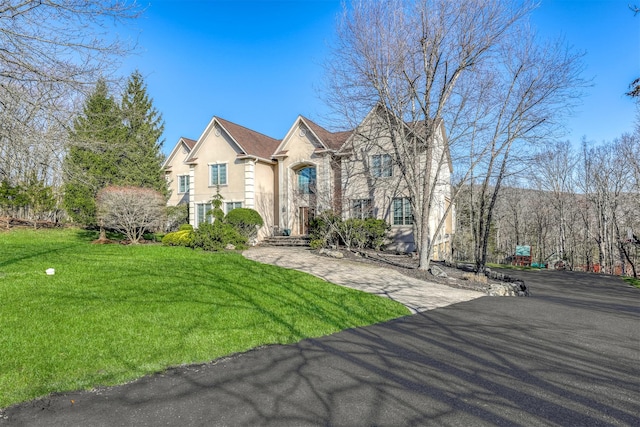 view of front facade with a front lawn, aphalt driveway, and stucco siding
