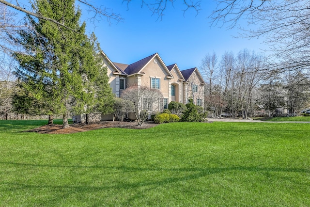 view of front of property with stucco siding and a front lawn