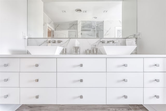bathroom featuring double vanity, visible vents, and a sink