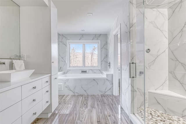 bathroom featuring a garden tub, visible vents, vanity, and a marble finish shower