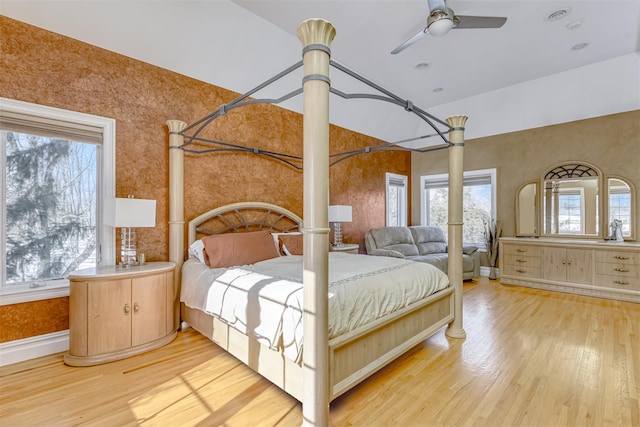 bedroom with light wood-style flooring and decorative columns