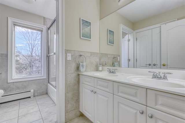 bathroom featuring tile walls, double vanity, a sink, and a baseboard radiator