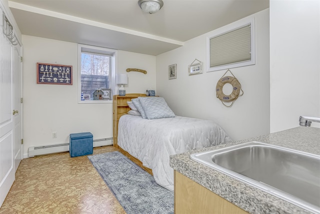 bedroom featuring a baseboard heating unit and a sink