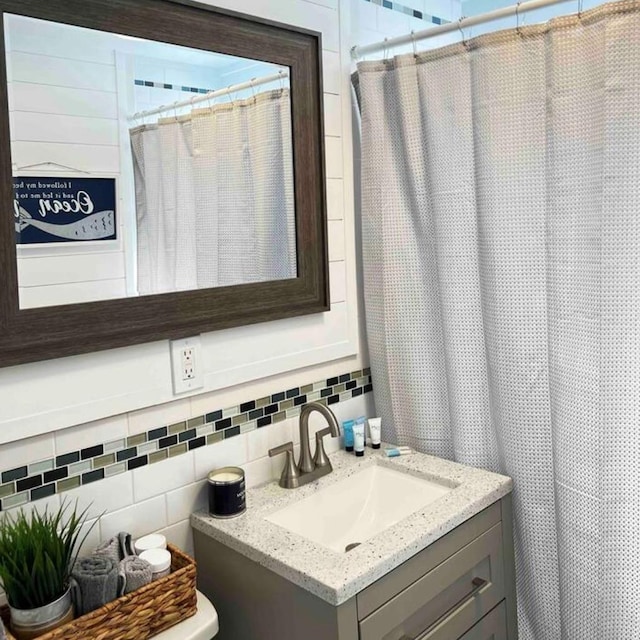 bathroom with curtained shower, vanity, and decorative backsplash