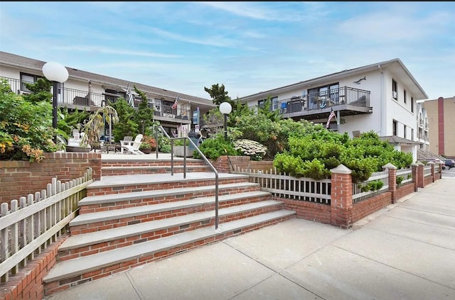 view of property's community with fence and a patio