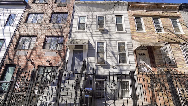 multi unit property featuring a fenced front yard and cooling unit