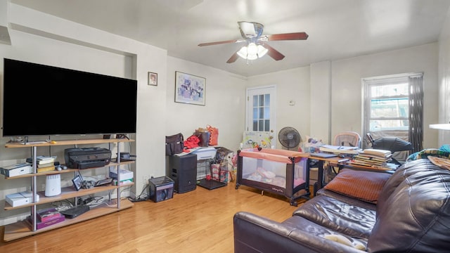 living area featuring light wood-style floors and a ceiling fan