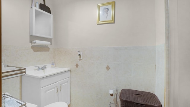 bathroom featuring a wainscoted wall, tile walls, and vanity