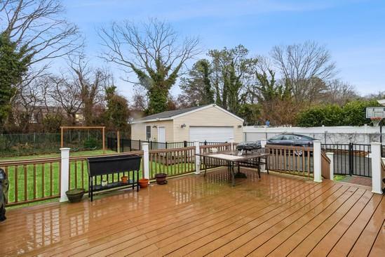 wooden deck featuring an outdoor structure and a lawn