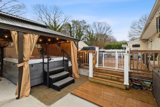 wooden deck featuring a hot tub