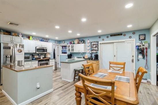 kitchen featuring stainless steel appliances, light wood finished floors, and visible vents