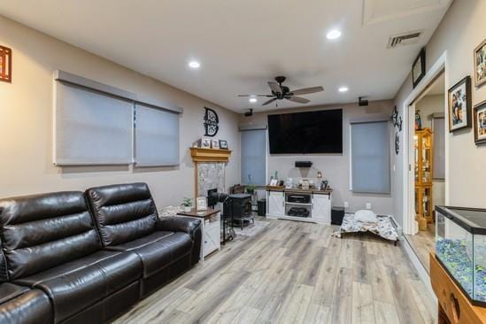 living area with a ceiling fan, wood finished floors, visible vents, and recessed lighting