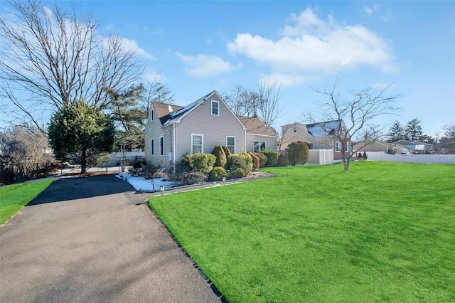 view of home's exterior with a lawn and fence