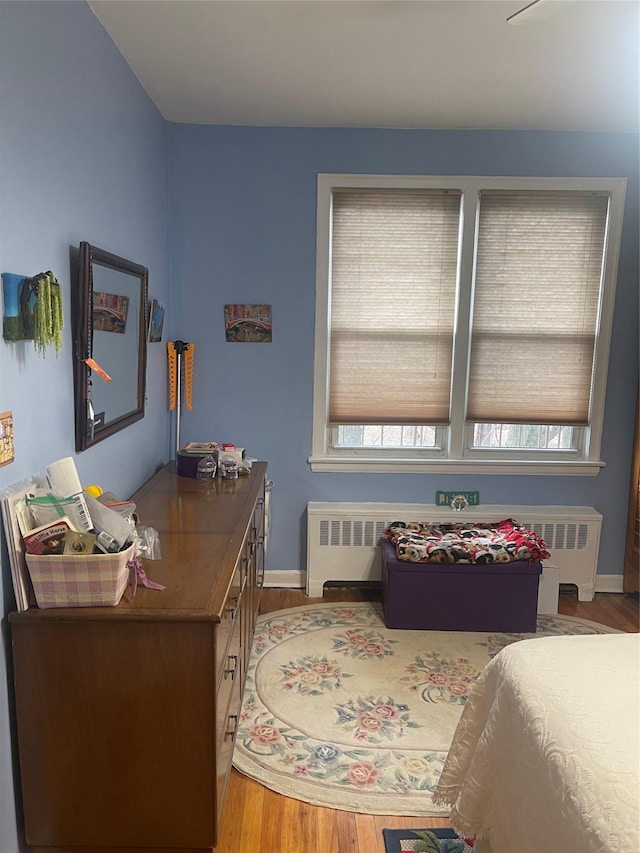 office area with a healthy amount of sunlight, radiator, baseboards, and wood finished floors