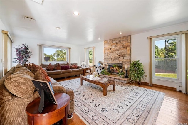 living room featuring recessed lighting, a fireplace, wood finished floors, and baseboards