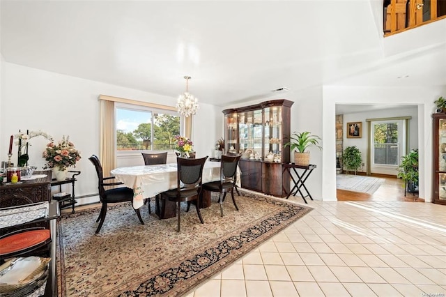 dining room featuring a healthy amount of sunlight, visible vents, a notable chandelier, and light tile patterned flooring