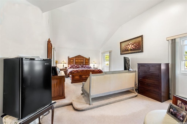 bedroom with light carpet, vaulted ceiling, and freestanding refrigerator