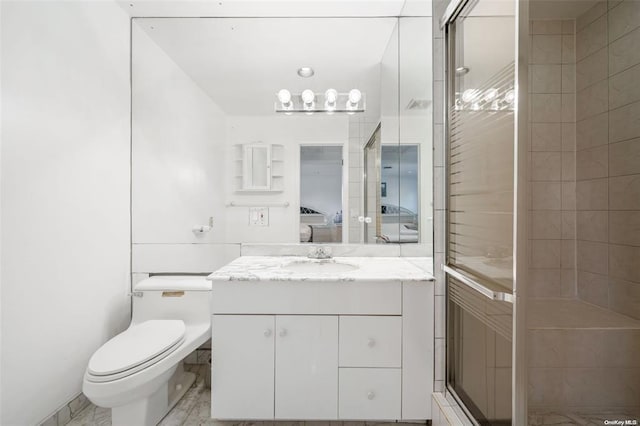 bathroom with toilet, a shower stall, and vanity