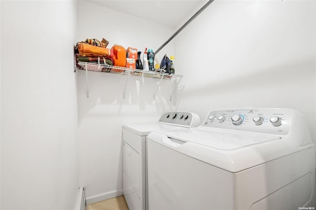 laundry area featuring laundry area, a baseboard radiator, washing machine and dryer, and baseboards