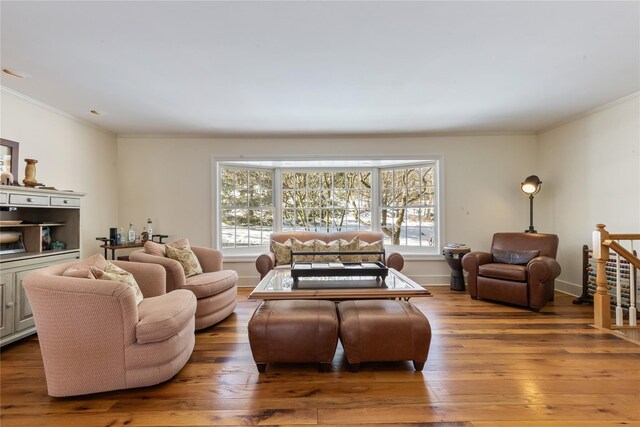 living area featuring a healthy amount of sunlight, crown molding, and wood finished floors