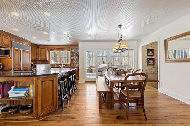 dining space with wood-type flooring, a notable chandelier, and recessed lighting