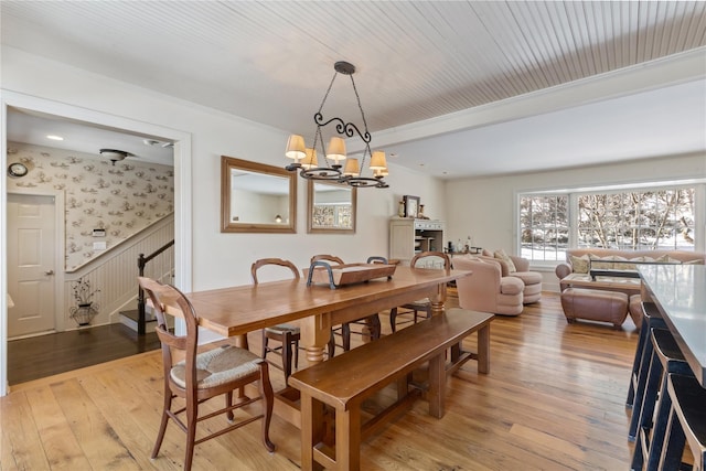 dining room with stairs, wallpapered walls, a notable chandelier, and light wood-style floors