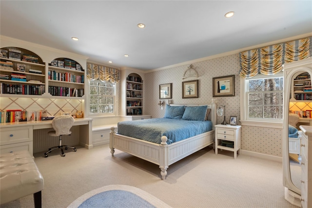 bedroom featuring recessed lighting, ornamental molding, built in study area, light carpet, and wallpapered walls