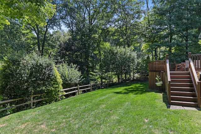 view of yard with stairs, a deck, and fence