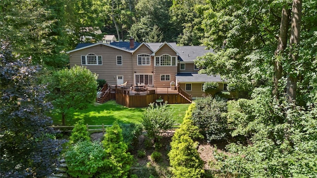 rear view of property featuring stairway, a wooden deck, and a lawn