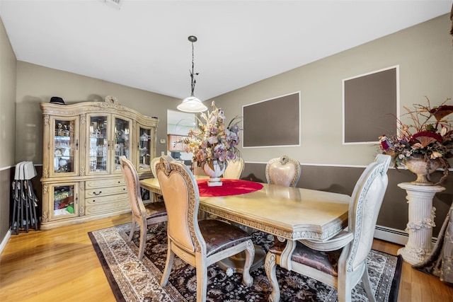 dining room featuring a baseboard radiator and wood finished floors