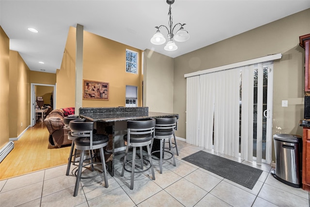 dining room featuring light tile patterned floors, baseboards, a notable chandelier, and recessed lighting