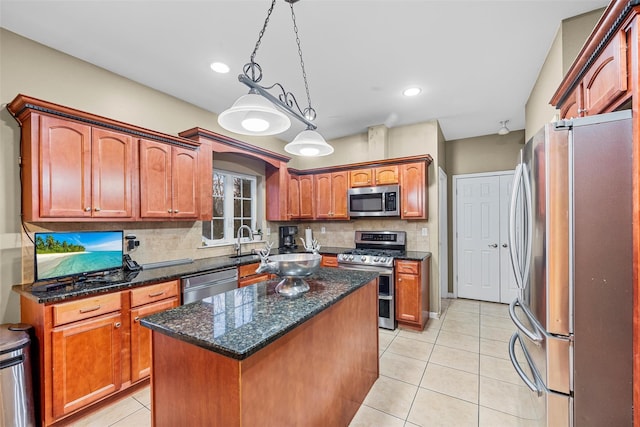 kitchen with appliances with stainless steel finishes, a center island, hanging light fixtures, backsplash, and light tile patterned flooring