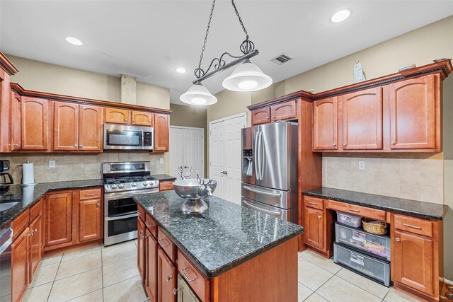 kitchen featuring visible vents, a kitchen island, decorative light fixtures, stainless steel appliances, and light tile patterned flooring