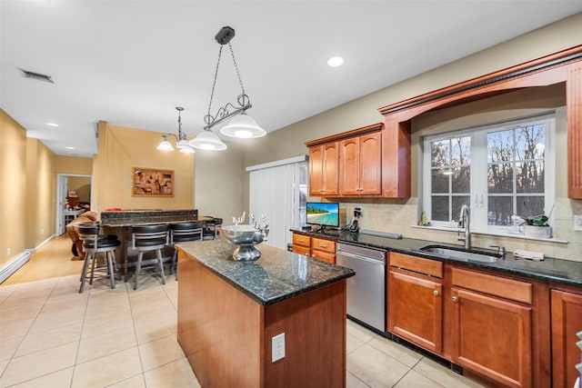 kitchen with a kitchen island, visible vents, a sink, dishwasher, and decorative light fixtures