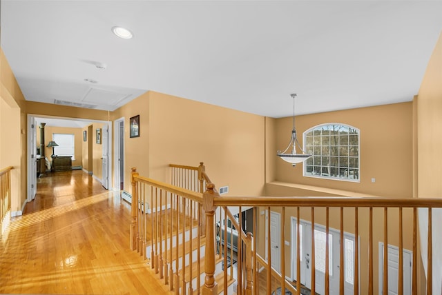 hallway featuring recessed lighting, visible vents, wood finished floors, and an upstairs landing